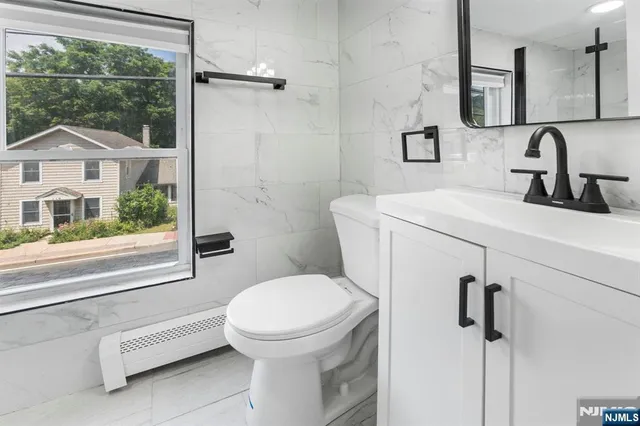 a bathroom with a sink a toilet and a mirror