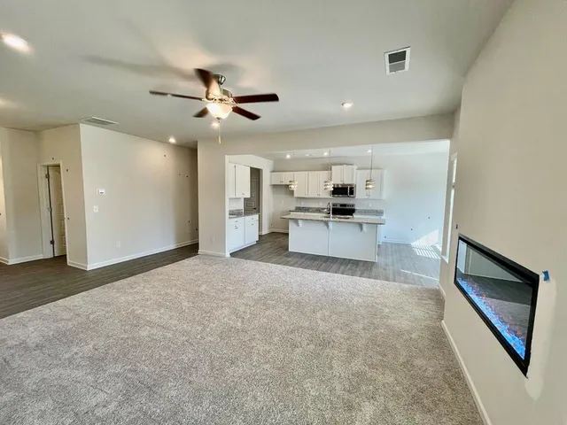 a kitchen with stainless steel appliances granite countertop a sink a stove and a wooden floors