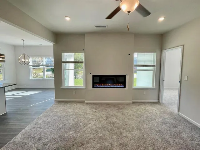 an empty room with windows and fireplace