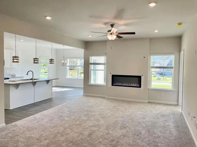 an empty room with windows and fireplace