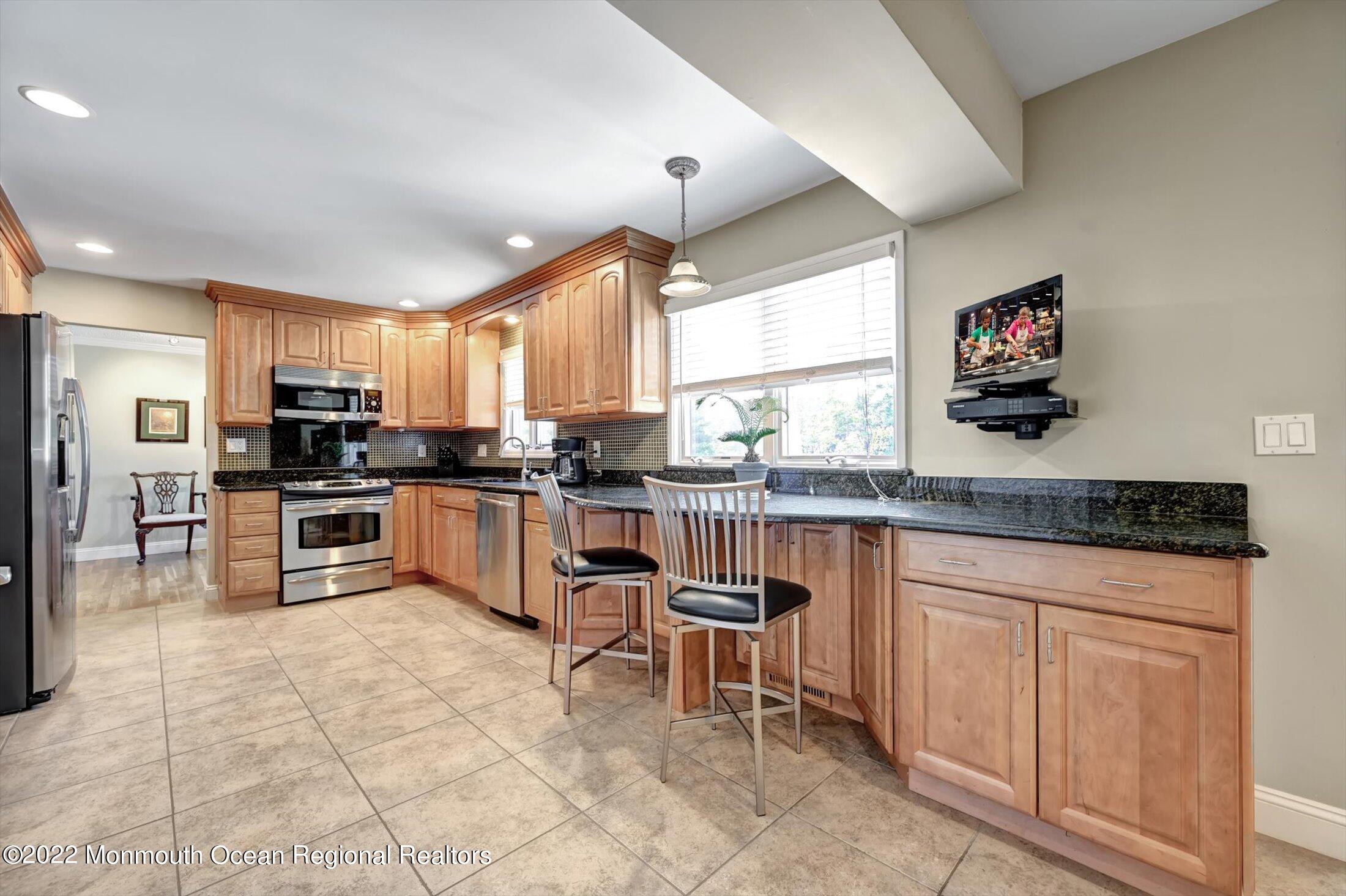 4 Sussex Road Morganville, NJ 07751 - Photo 11 of 55 a kitchen with granite countertop a stove top oven a sink a counter space and cabinets