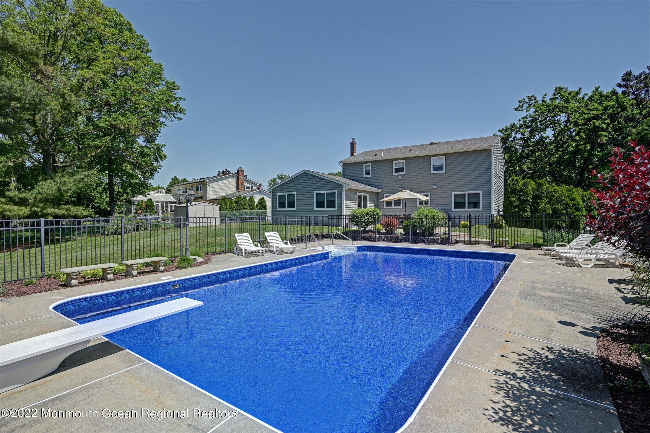 4 Sussex Road Morganville, NJ 07751 - Photo 41 of 55 a view of swimming pool with seating space and trees in the background