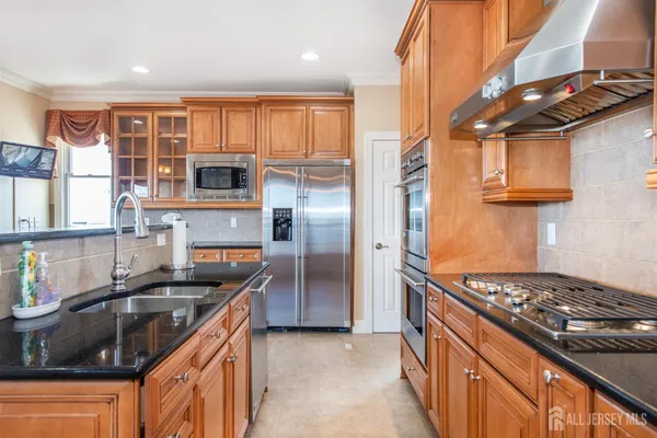 a kitchen with stainless steel appliances granite countertop a sink stove and refrigerator