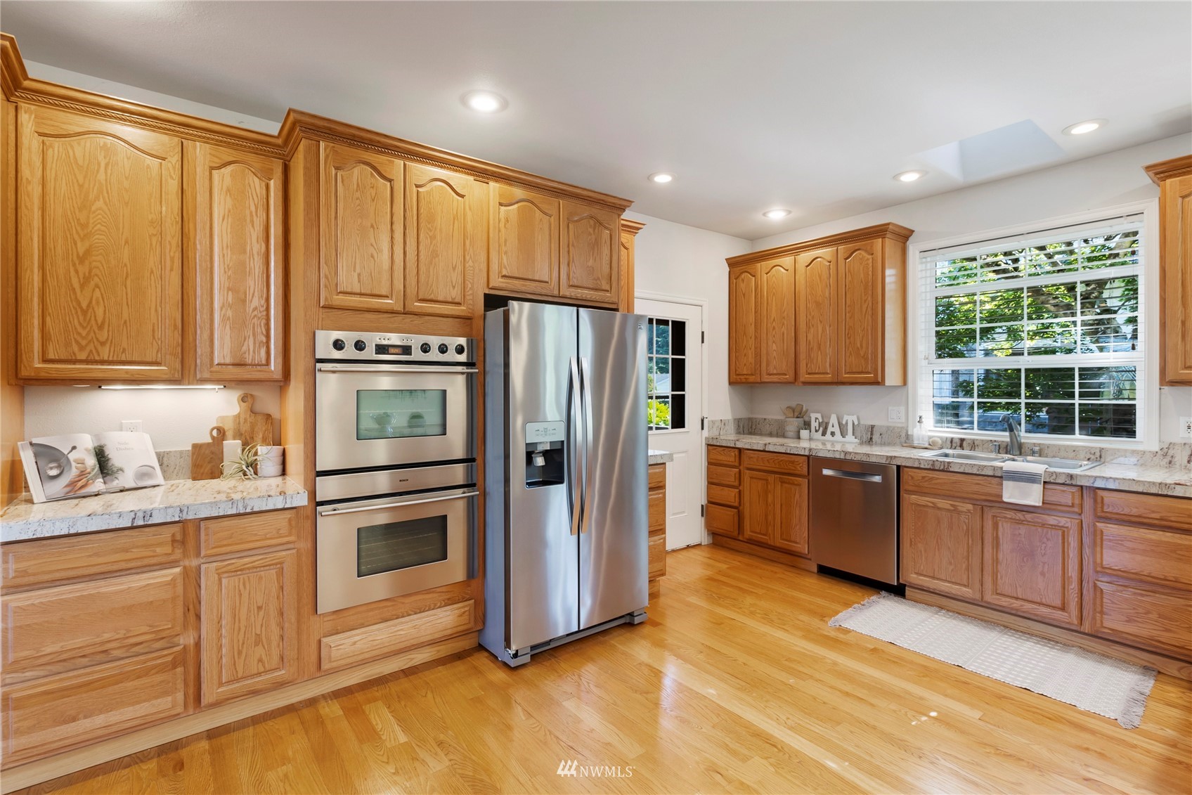 3904 Park Avenue North Renton, WA 98056 - Photo 14 of 40 a kitchen with stainless steel appliances granite countertop a refrigerator a stove and a sink with cabinets