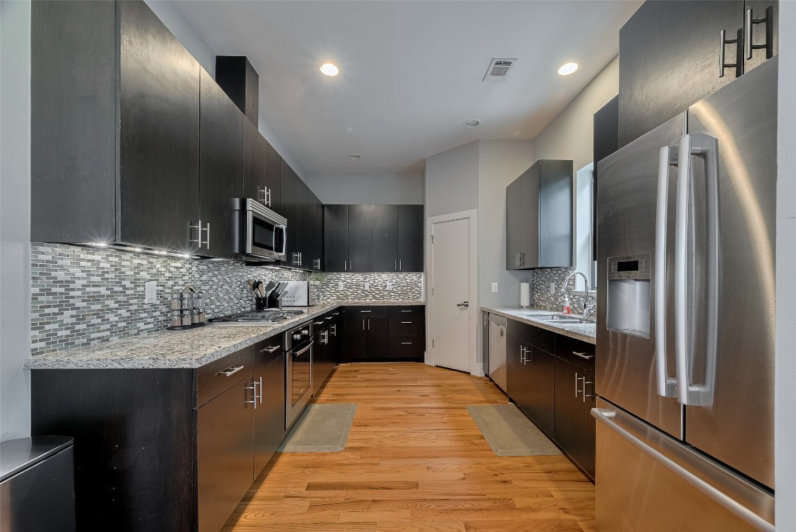 2115 Hadley Street Houston, TX 77003 - Photo 12 of 34 a large kitchen with stainless steel appliances granite countertop a sink stove and refrigerator