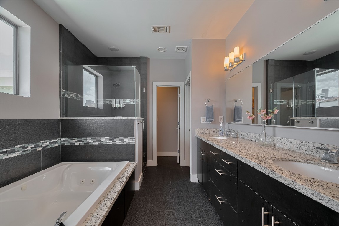 2115 Hadley Street Houston, TX 77003 - Photo 19 of 34 a bathroom with a granite countertop bathtub a double vanity sink and a large mirror