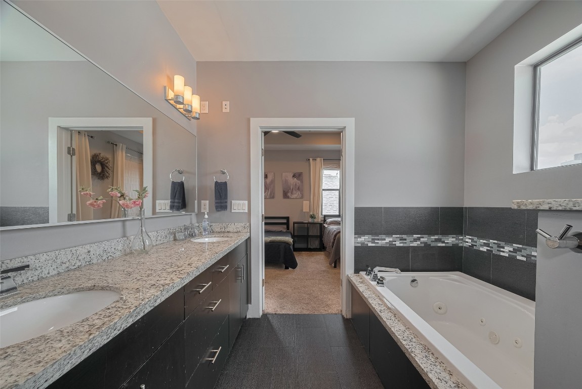 2115 Hadley Street Houston, TX 77003 - Photo 23 of 34 a bathroom with a granite countertop tub a double vanity sink and a large mirror