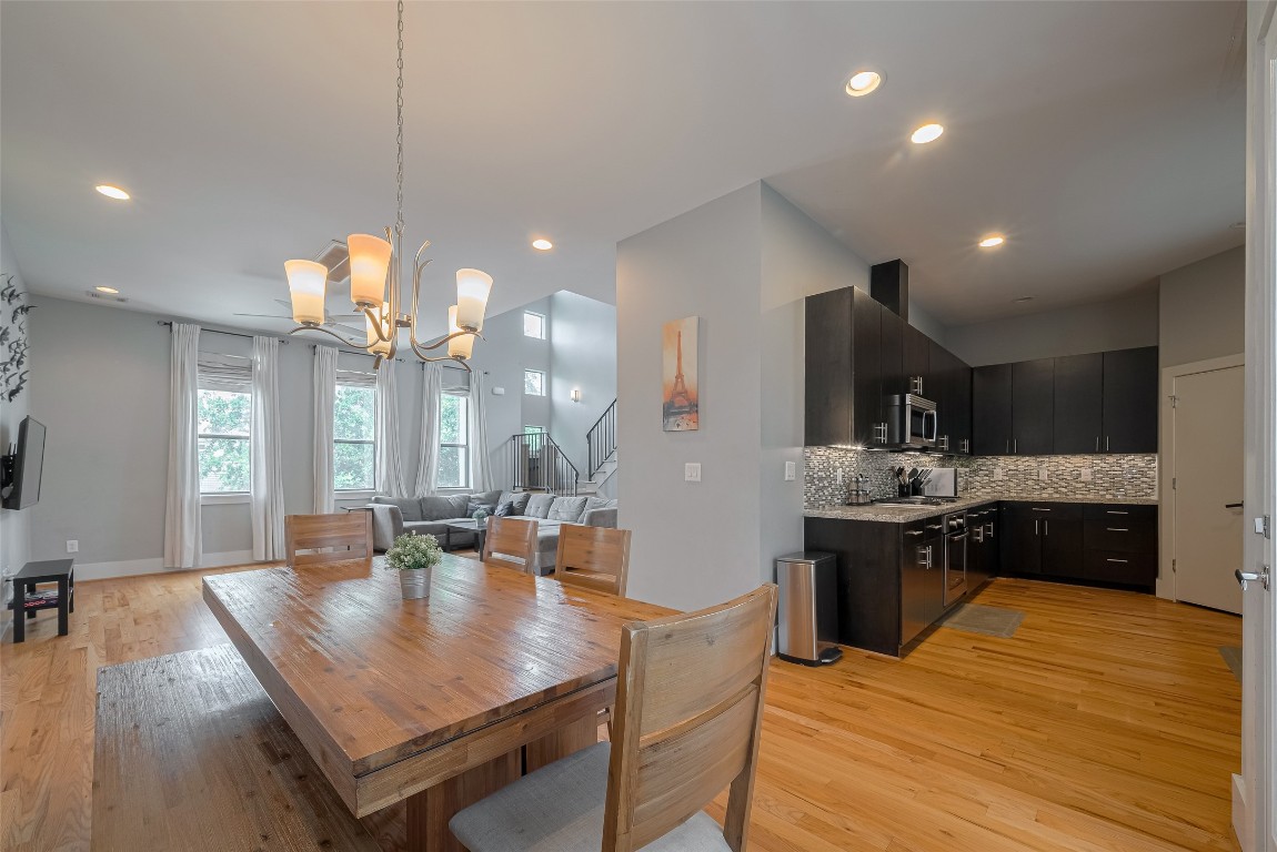 2115 Hadley Street Houston, TX 77003 - Photo 5 of 34 a kitchen with a dining table wooden floor stainless steel appliances and living room view