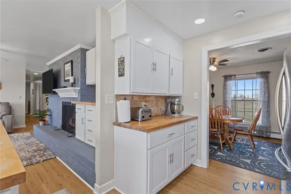 a kitchen with stainless steel appliances granite countertop a stove top oven a sink dishwasher and white cabinets with wooden floor