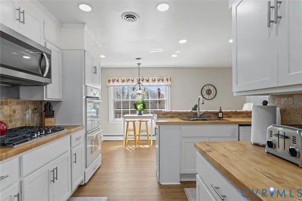 a kitchen with kitchen island granite countertop a sink stove and cabinets