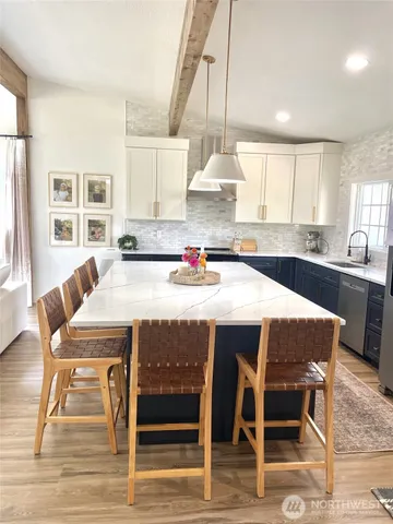 a kitchen with a table chairs sink and cabinets