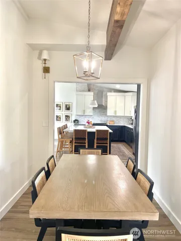 a living room with chairs pool table and chandelier