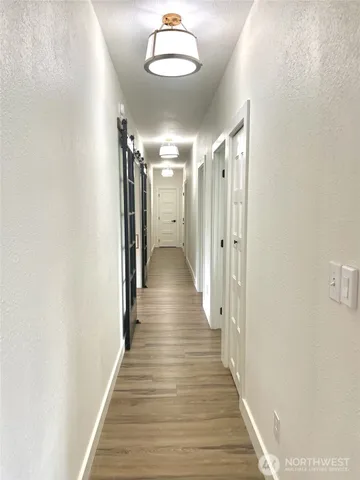 a view of a hallway with wooden floor