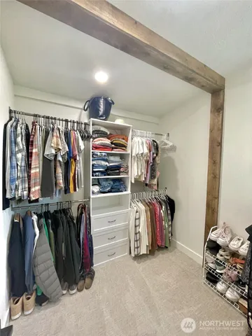 a view of walk in closet with clothes and shoes