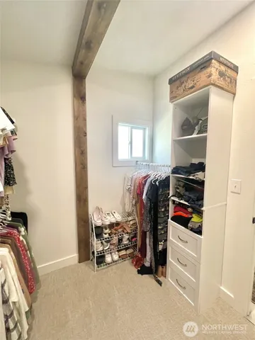 a view of walk in closet with clothes and shoes