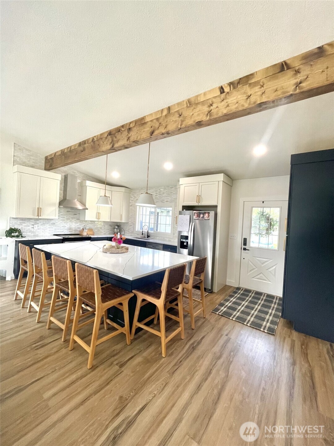 6694 Mae Valley Road Northeast Moses Lake, WA 98837 - Photo 9 of 26 a dining hall with stainless steel appliances kitchen island granite countertop a table chairs and a refrigerator