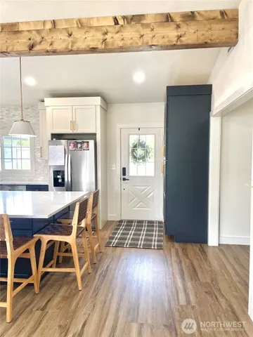 an open kitchen with granite countertop a stove and white cabinets