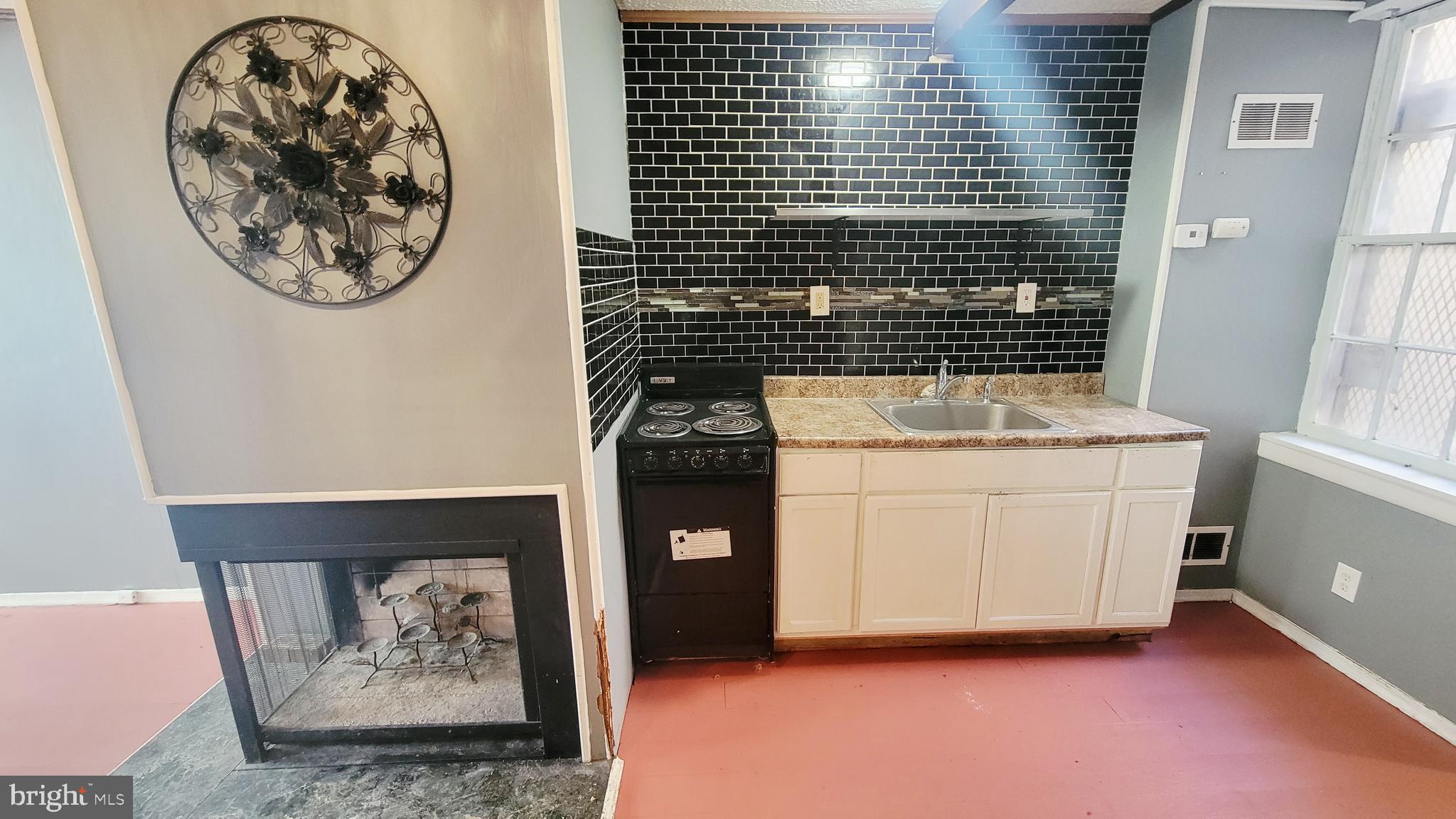 703 Tessier Street Baltimore, MD 21201 - Photo 7 of 19 Kitchen and fireplace