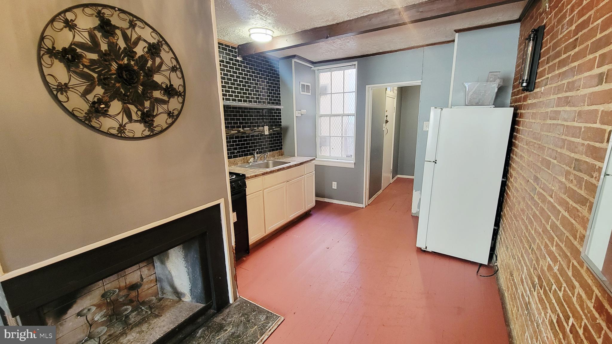 703 Tessier Street Baltimore, MD 21201 - Photo 8 of 19 Kitchen and fireplace
