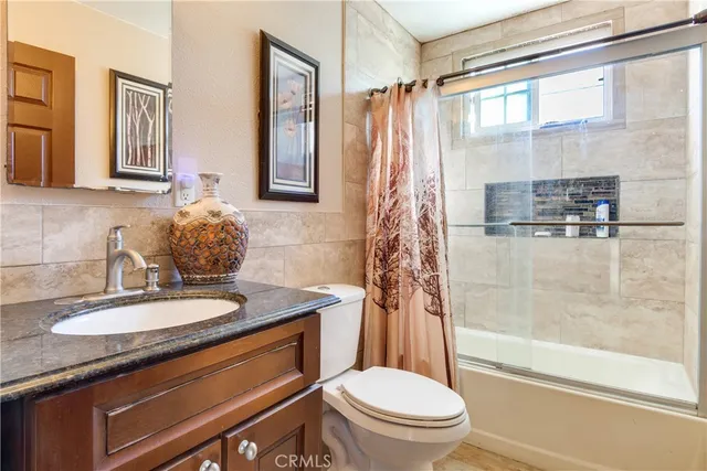 a bathroom with a granite countertop sink toilet and shower