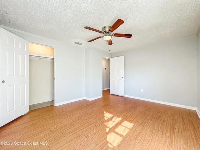 a view of a big room with wooden floor and windows in a room