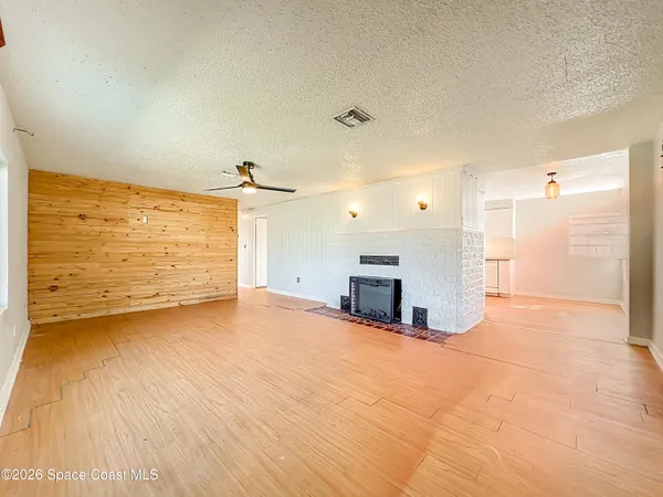a view of a room with kitchen appliances and wooden floor