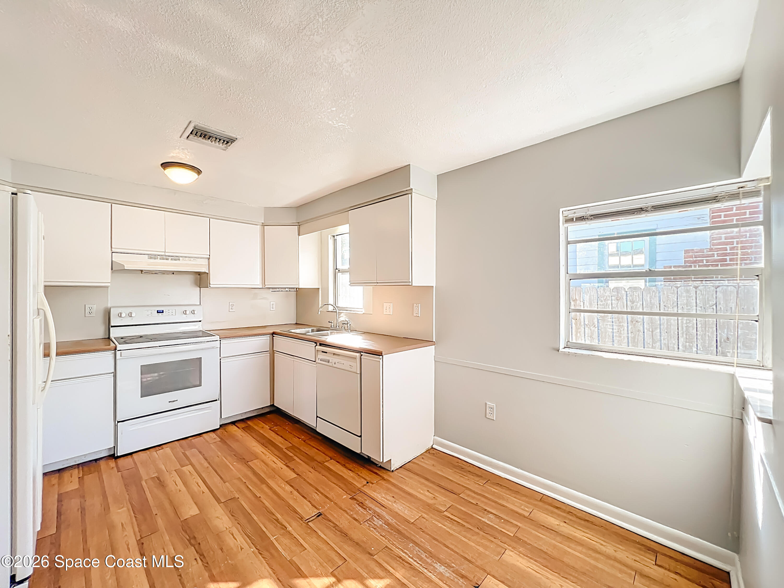 541 East Fee Avenue Melbourne, FL 32901 - Photo 8 of 28 a kitchen with granite countertop white cabinets and white appliances
