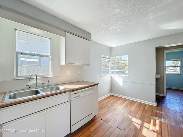 a kitchen with a sink window and cabinets