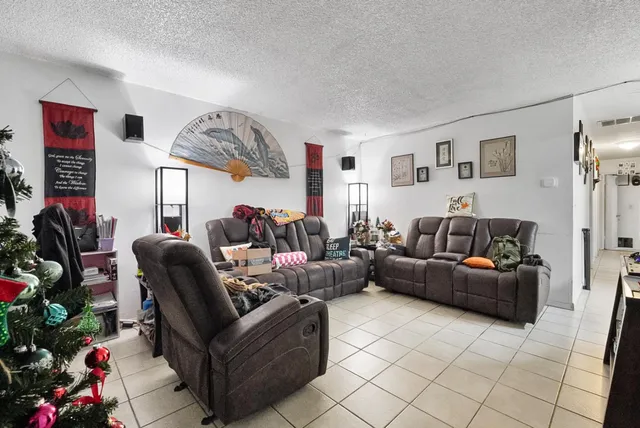 a living room with furniture and a potted plant