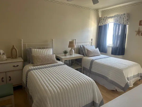 a bedroom with two beds and painting on the wall
