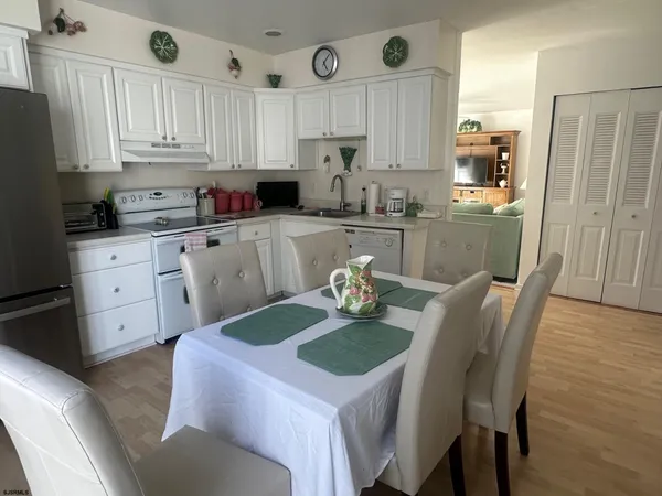 a kitchen with stainless steel appliances granite countertop a sink a stove a refrigerator a microwave oven with cabinets and wooden floor