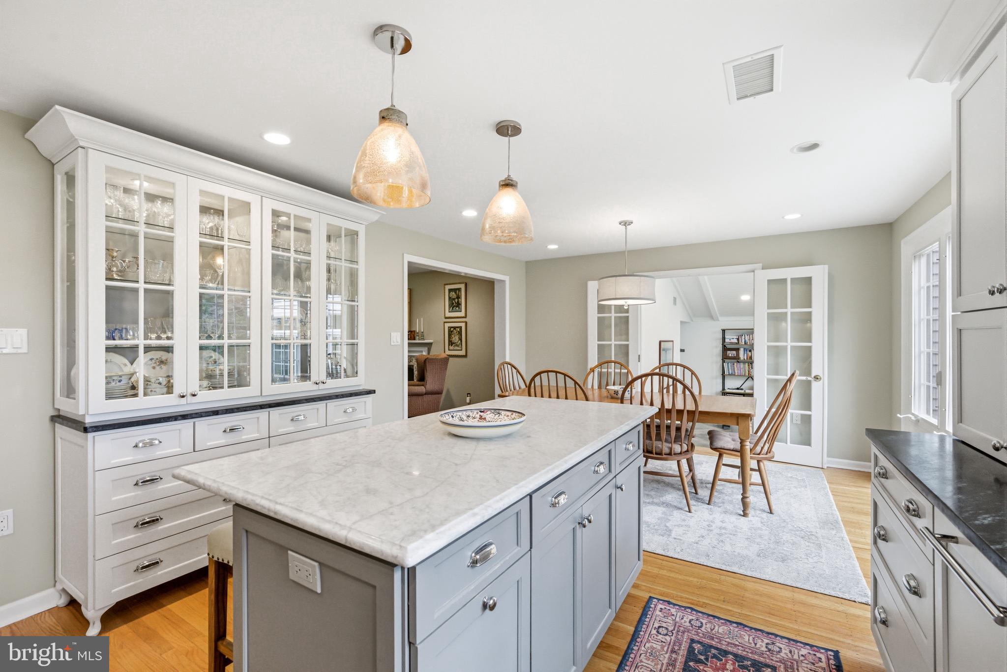 371 Margo Lane Berwyn, PA 19312 - Photo 16 of 68 a open kitchen with stainless steel appliances granite countertop a stove top oven a dining table and chairs with wooden floor