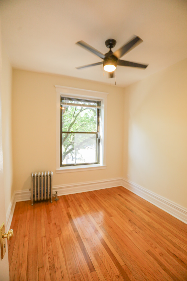 1848 West Grace Street, Unit 2E Chicago, IL 60613 - Photo 12 of 13 a view of an empty room with wooden floor and a window