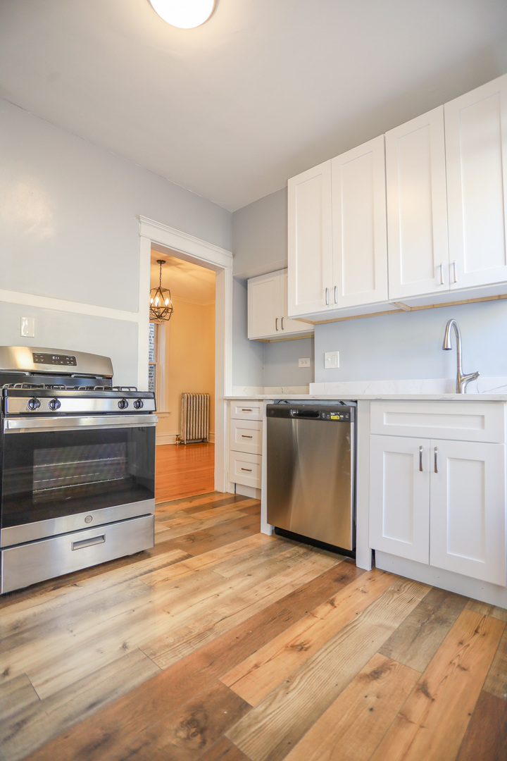 1848 West Grace Street, Unit 2E Chicago, IL 60613 - Photo 3 of 13 a kitchen with granite countertop a stove top oven and cabinets