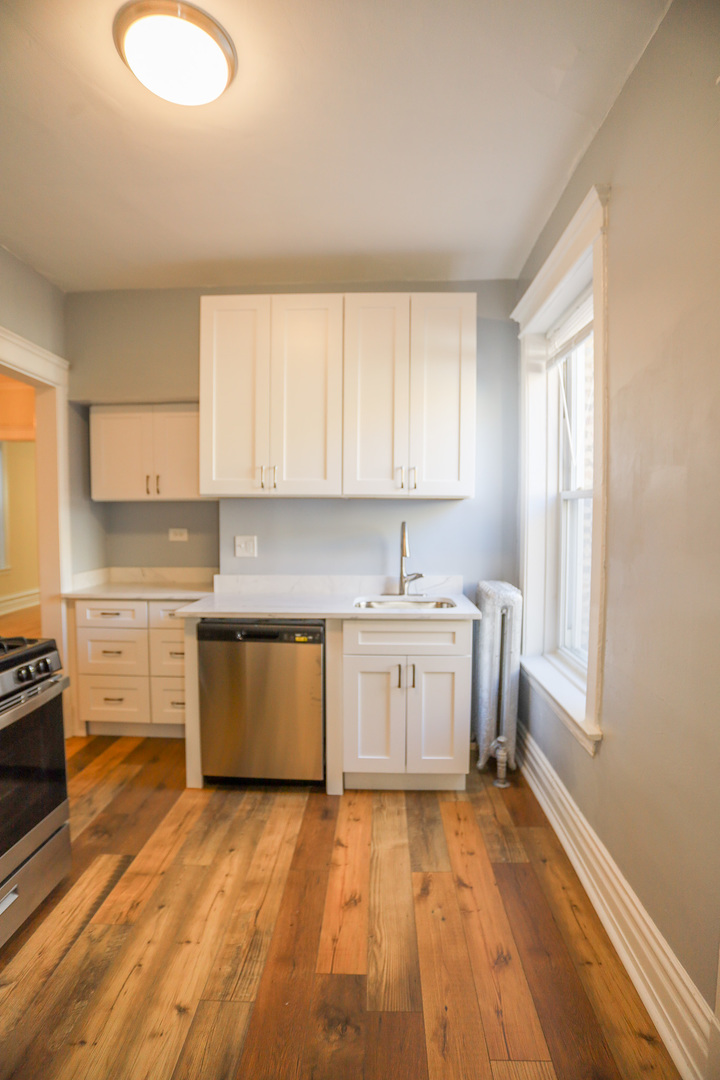 1848 West Grace Street, Unit 2E Chicago, IL 60613 - Photo 6 of 13 a kitchen with a sink a stove cabinets and wooden floor
