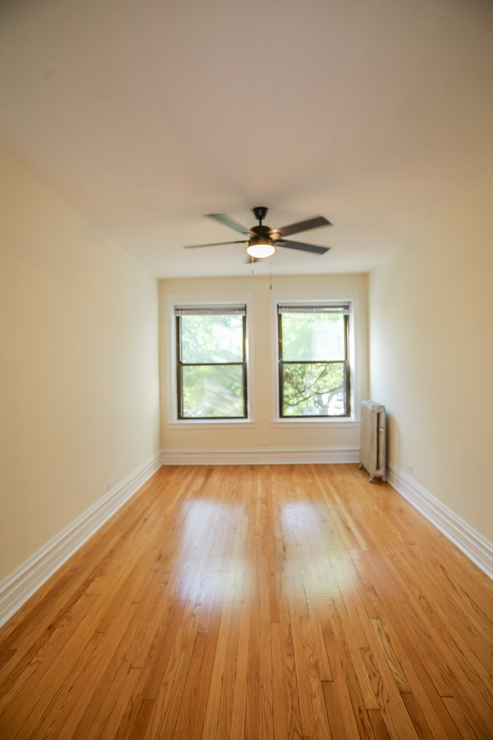 1848 West Grace Street, Unit 2E Chicago, IL 60613 - Photo 7 of 13 wooden floor in an empty room with a window