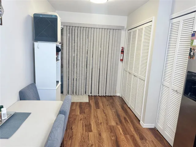 a view of a hallway with wooden floor and cabinet
