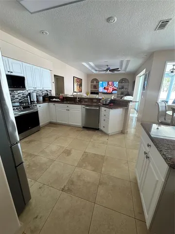 a kitchen with stainless steel appliances a sink a stove a microwave a sink a counter top space and cabinets