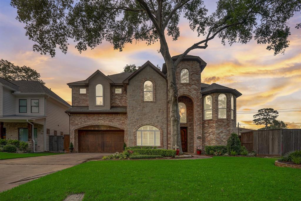 1518 Ebony is beautifully built using reclaimed bayou bend brick on the exterior and meticulously maintained in the heart of Oak Forest. It features a wooden garage door and lush evergreen landscaping.