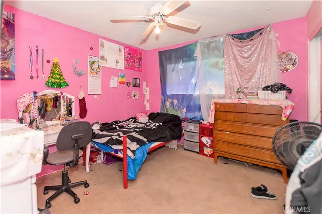 a bedroom with furniture and a fan