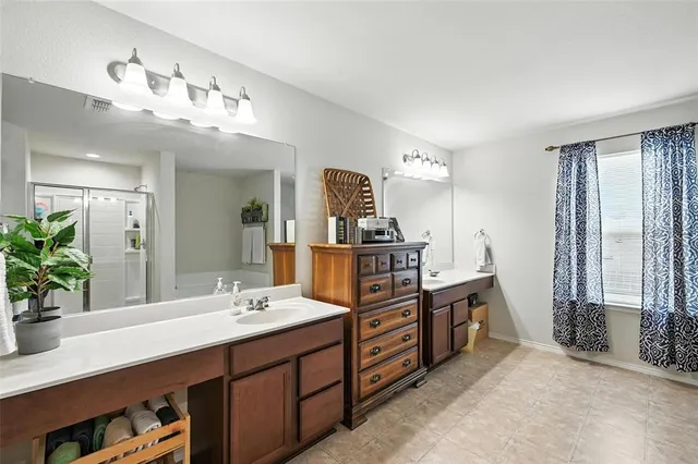 a spacious bathroom with a double vanity sink and a mirror