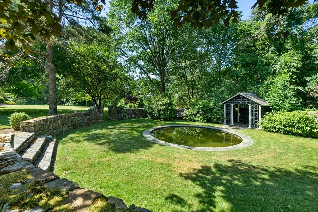 1 Rocky Ridge Road Dedham, MA 02026 - Photo 35 of 38 a view of a backyard with large trees and plants