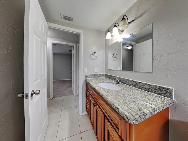 a bathroom with a granite countertop sink and a mirror