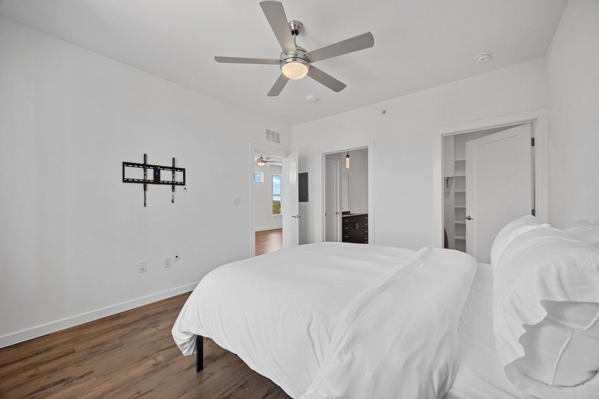 4801 Springdale Road, Unit 2301 Austin, TX 78723 - Photo 13 of 36 A well-lit bedroom features hardwood flooring and a modern ceiling fan for ultimate comfort.