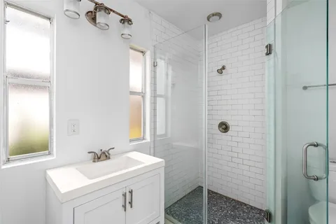 a bathroom with a sink a toilet and shower