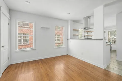 a view of a kitchen with wooden floor and windows