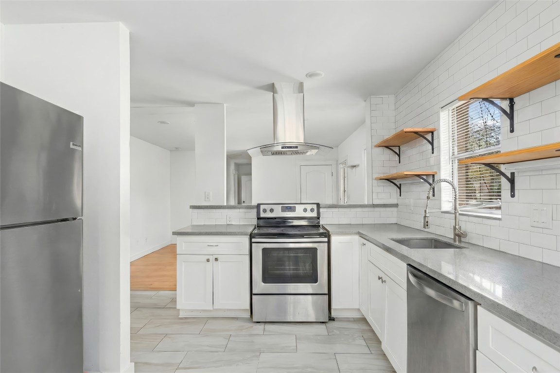 1740 Wroxton Court Houston, TX 77005 - Photo 7 of 27 a kitchen with stainless steel appliances granite countertop a sink a stove a refrigerator and a granite counter tops with white cabinets