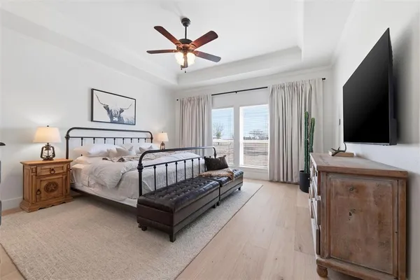 a spacious bedroom with a bed and a flat screen tv