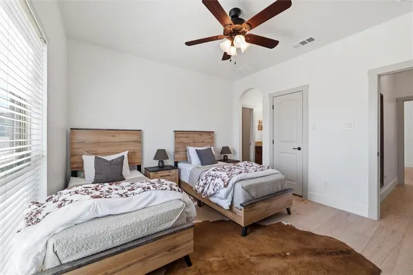 a bedroom with two large bed and a chandelier