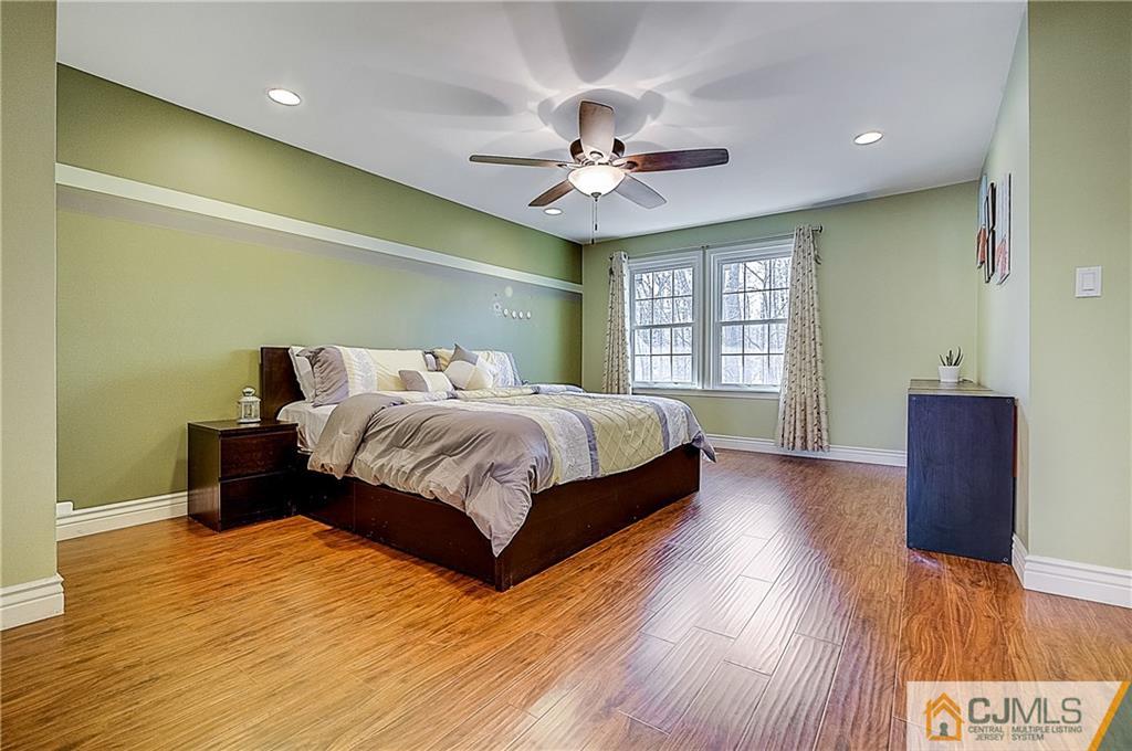 4505 Stonehedge Road Edison, NJ 08820 - Photo 12 of 25 a bedroom with a bed and wooden floor
